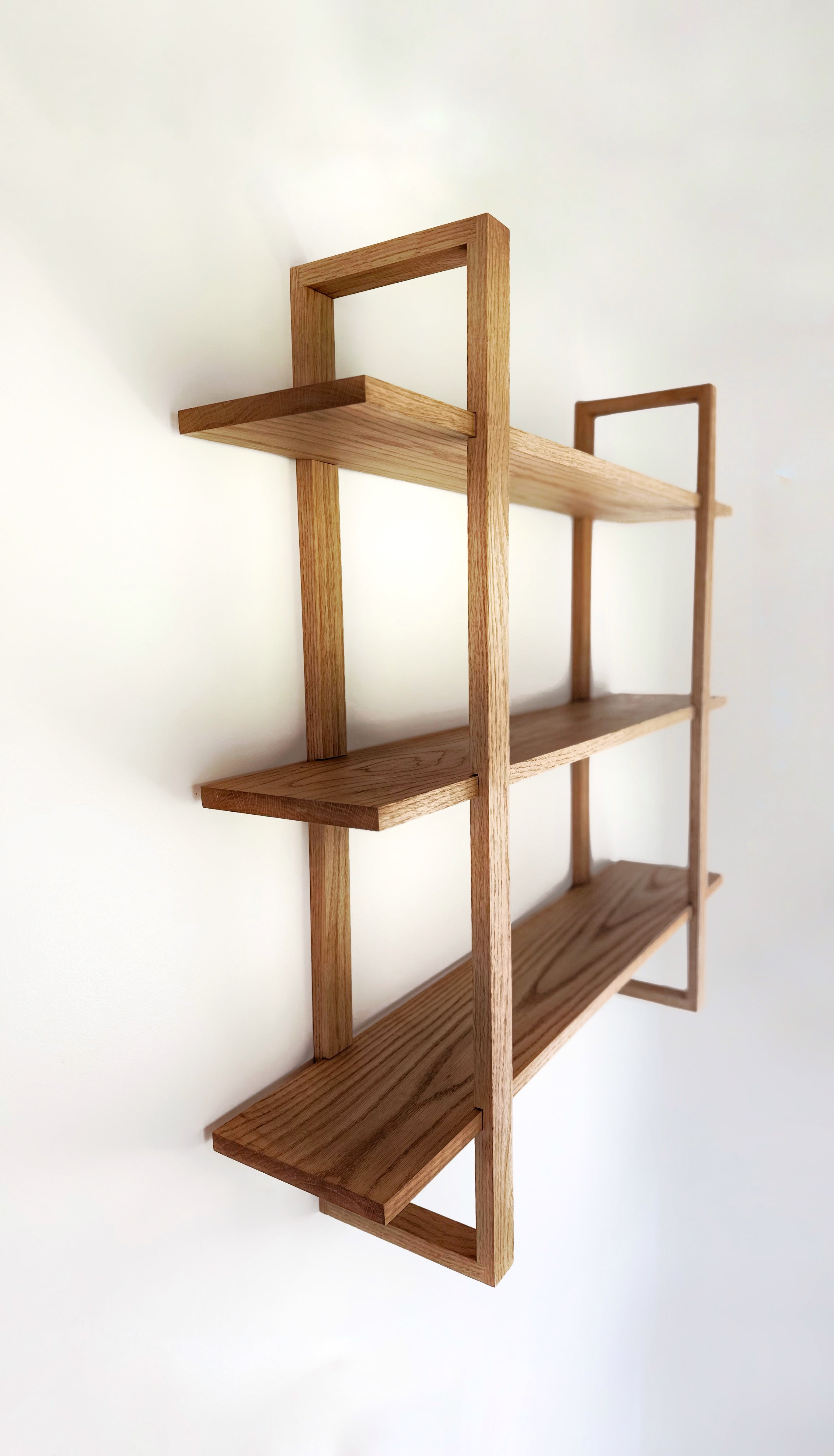 A minimalist solid wood floating shelf with a custom wall-mounted bracket, perfect for modern and contemporary home decor.