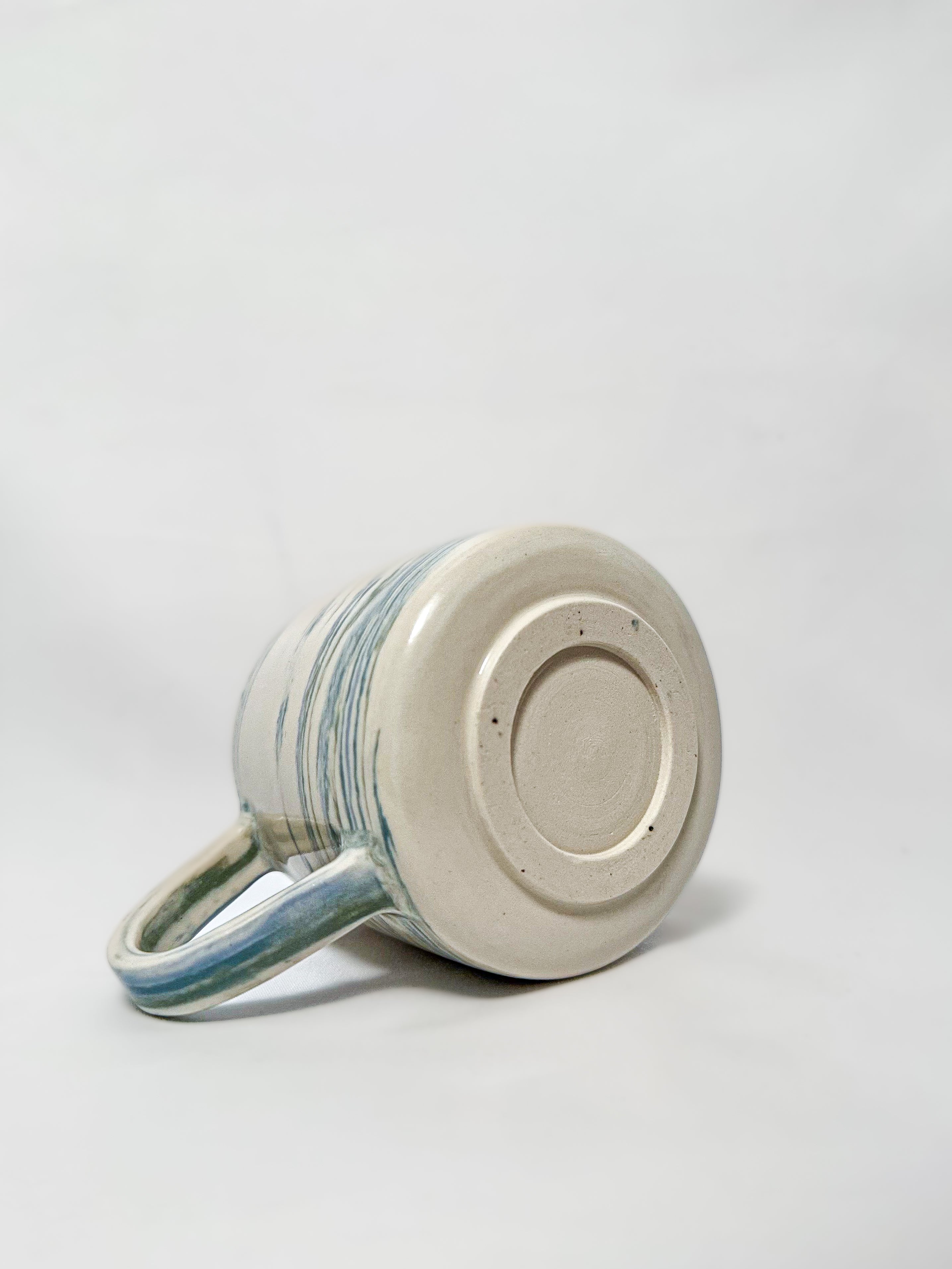 The bottom of a blue and white marbled stoneware mug