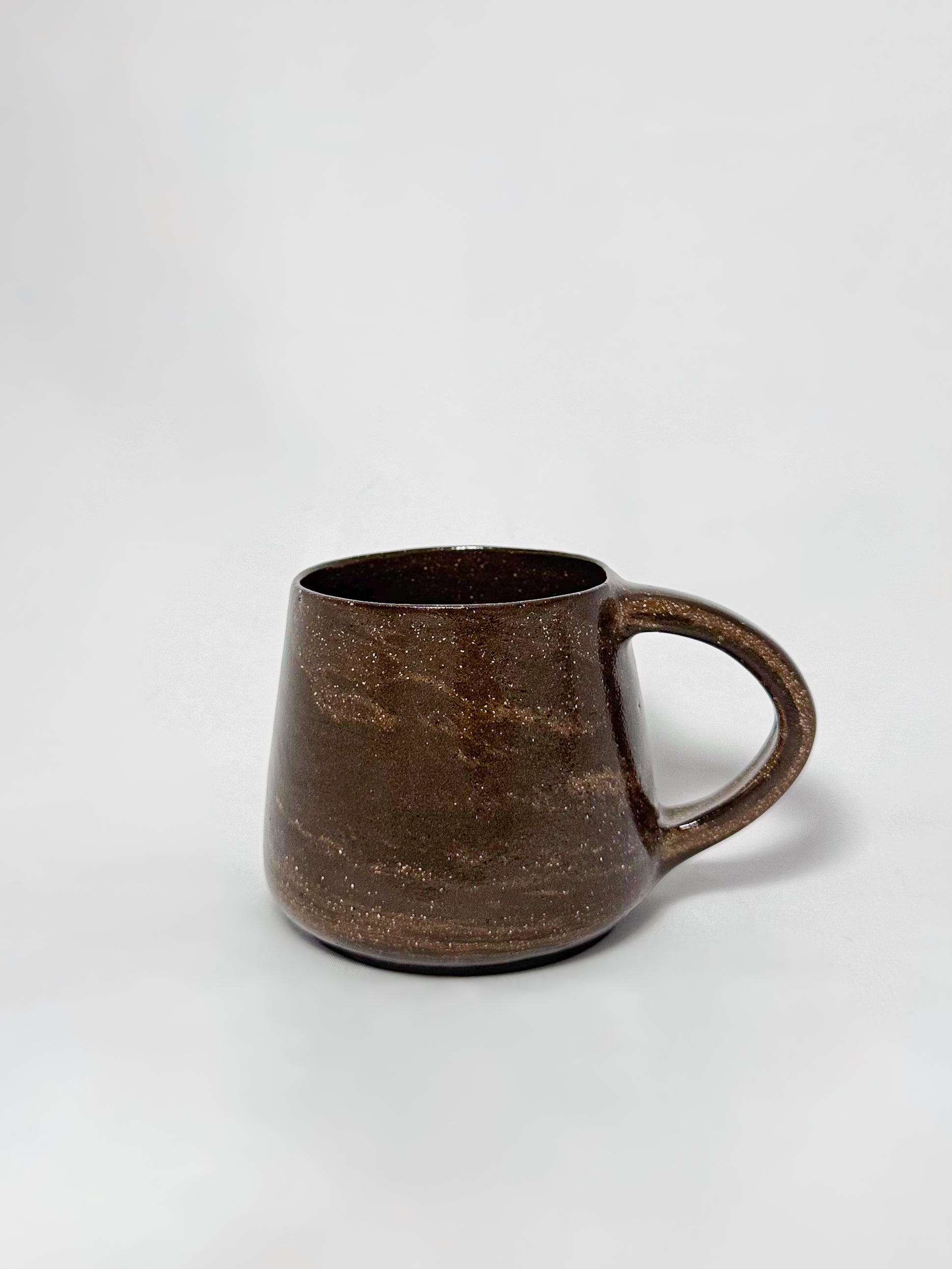 A brown marbled stoneware mug with swirls of light brown and dark brown clay