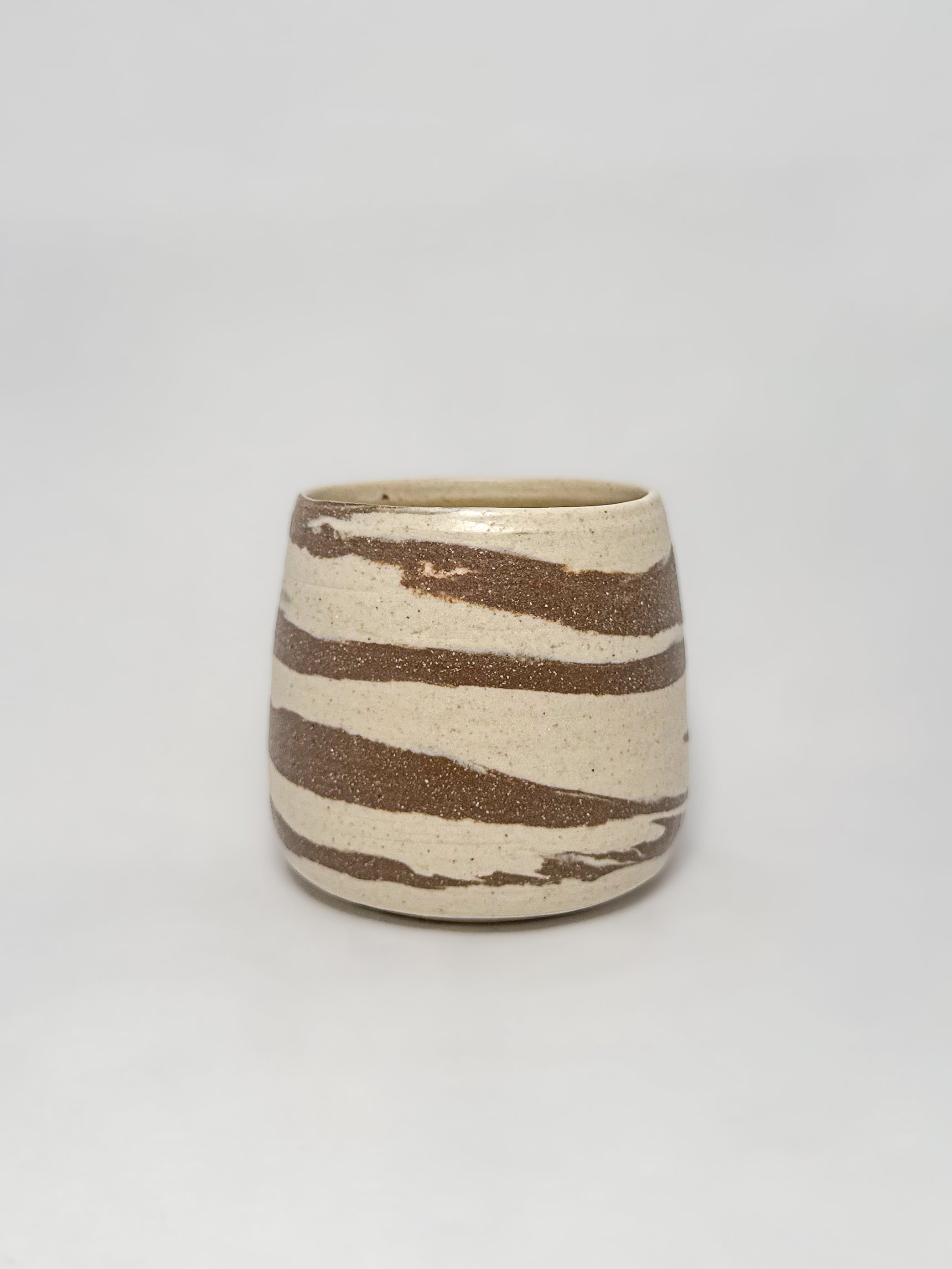A marbled ceramic stoneware tumbler with brown and white clay