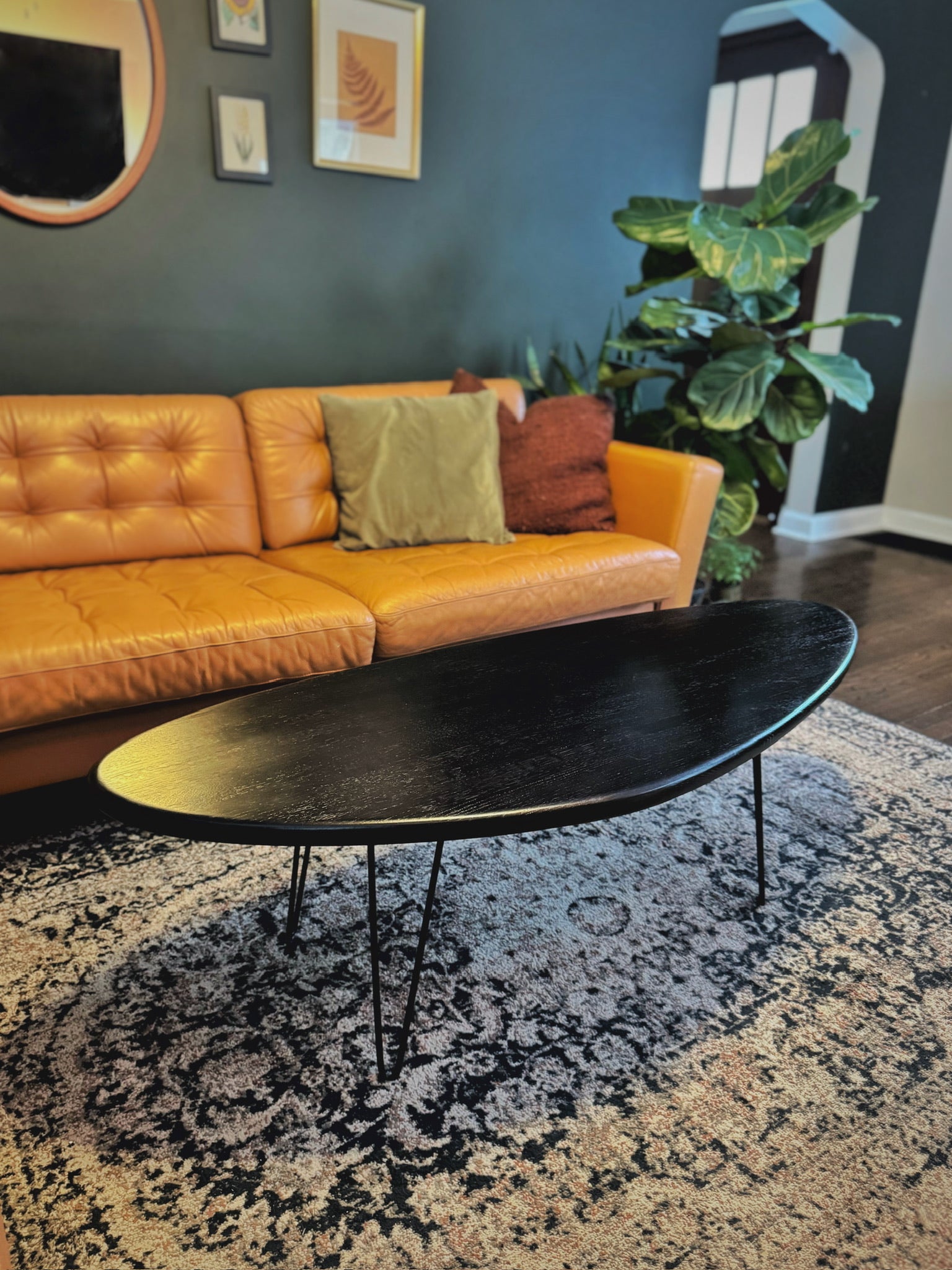 A vintage-inspired, mid-century modern kidney bean coffee table with a smooth solid wood surface and slim black hairpin legs for a minimalist touch, by Elmstone.