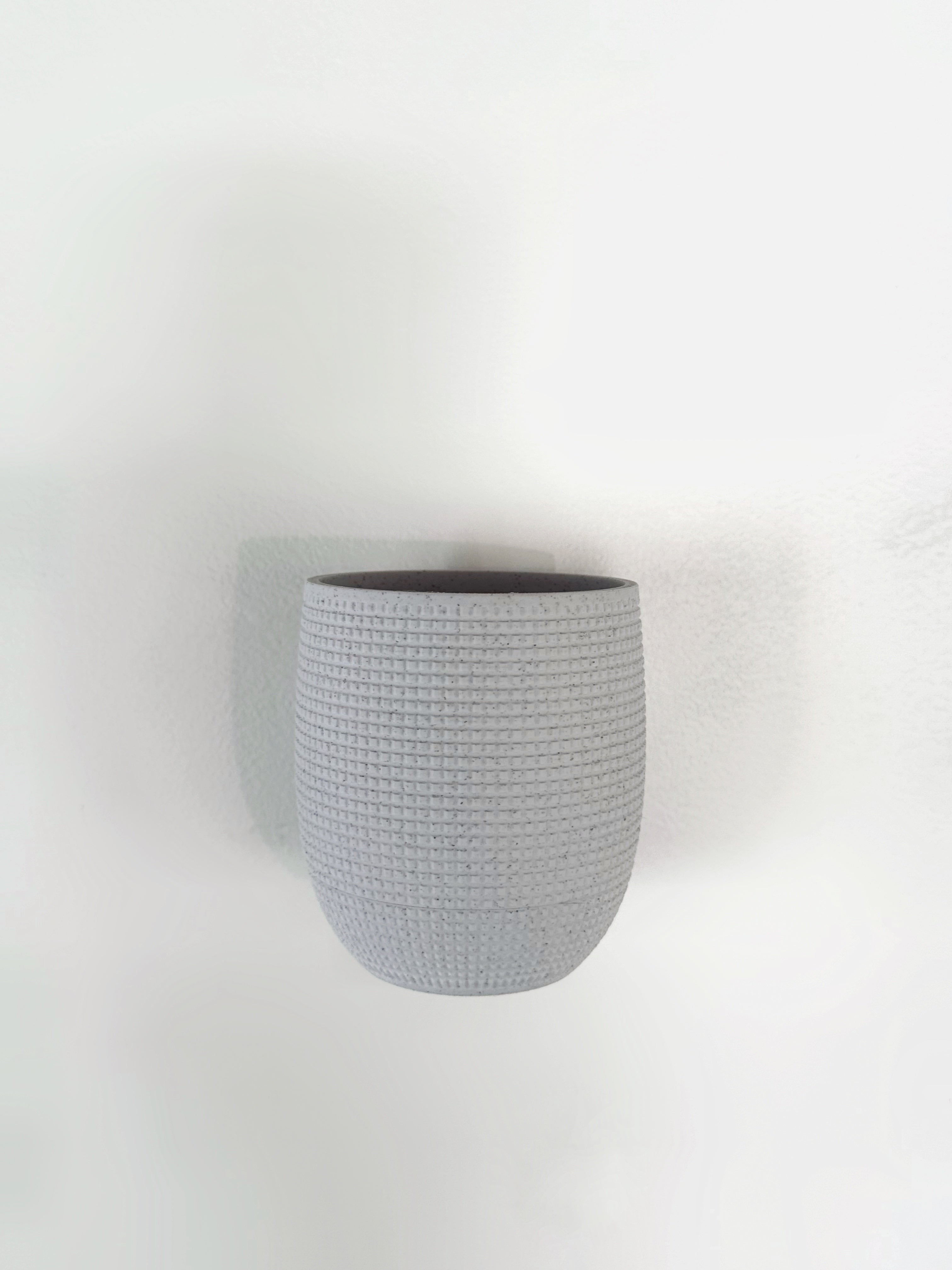 3D printed wall-mounted planter with hidden drip tray for indoor gardening. Stylish and functional plant pot, perfect for modern home decor. 