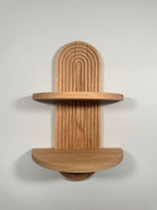 The Crescent small arch shelf made from solid oak, featuring two tiers for displaying decor. Mounts seamlessly on the wall with keyhole slots, hardware included.