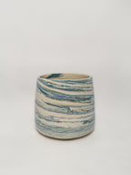 A blue and white marbled stoneware mug showing detailed unique swirls of blue and green clay