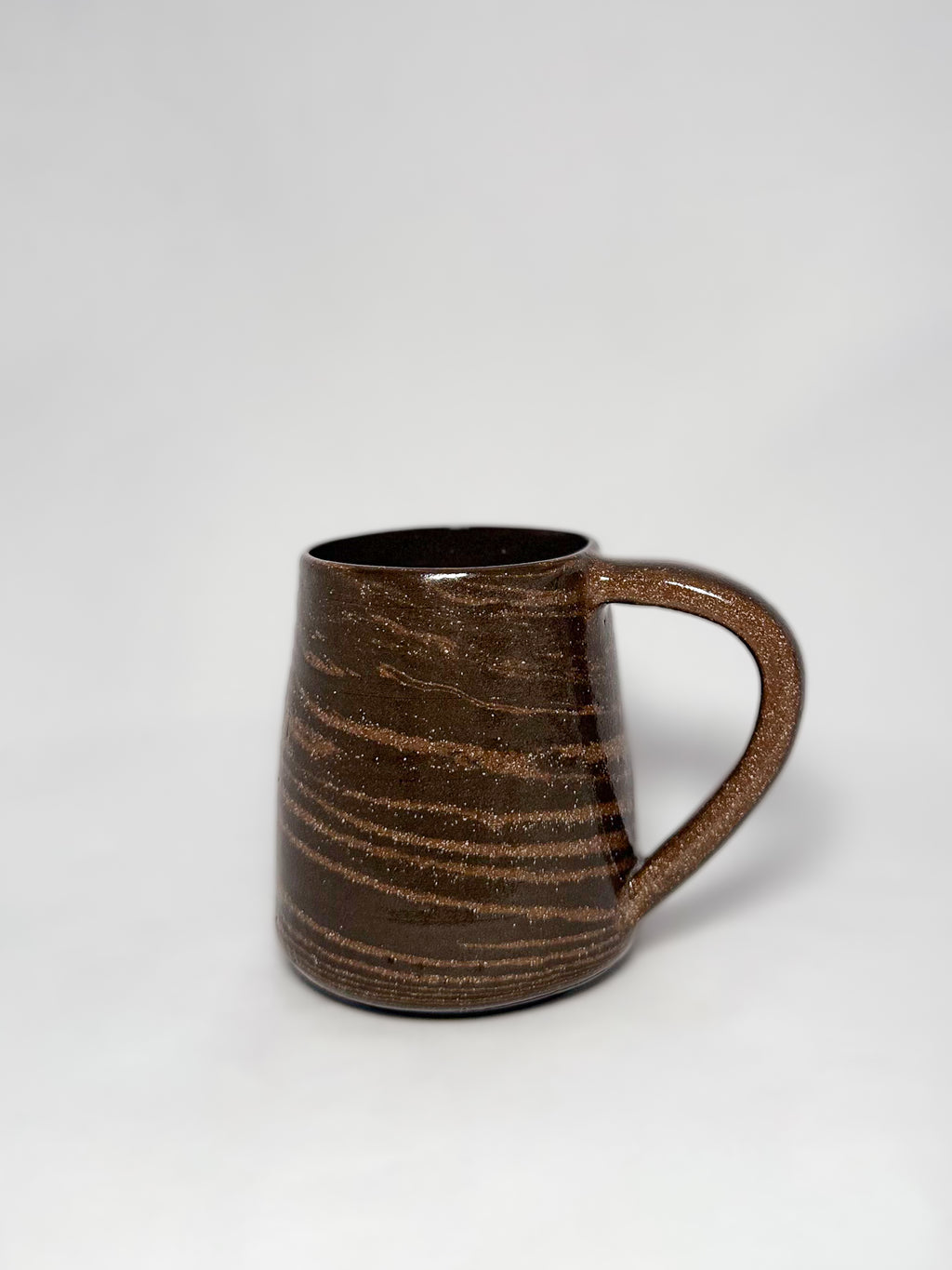 A brown marbled stoneware mug with swirls of light brown and dark brown clay