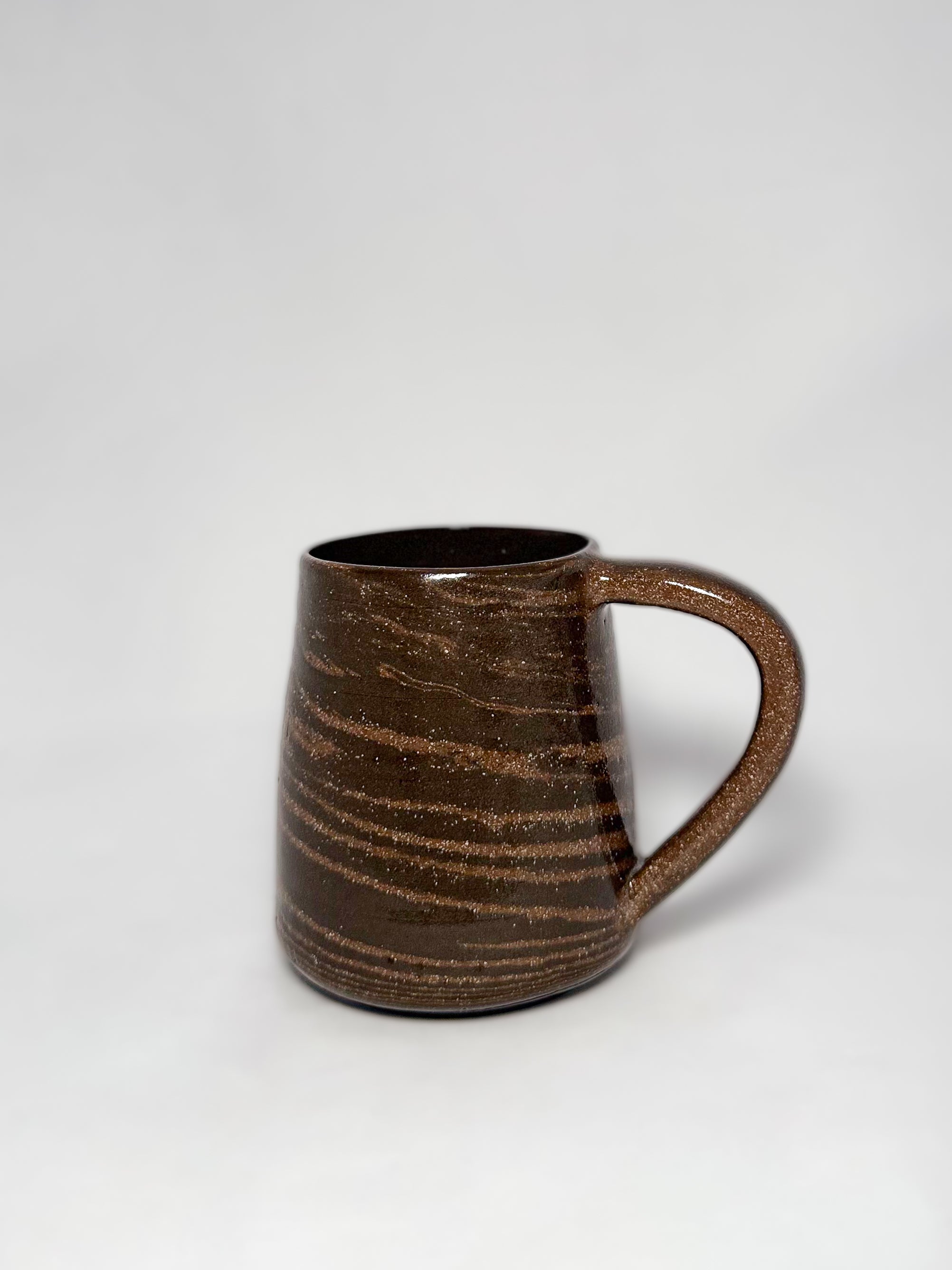 A brown marbled stoneware mug with swirls of light brown and dark brown clay