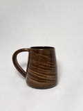 A brown marbled stoneware mug with swirls of light brown and dark brown clay