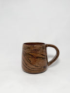 A brown marbled stoneware mug with swirls of light brown and dark brown clay