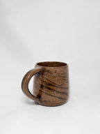 A brown marbled stoneware mug with swirls of light brown and dark brown clay