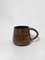 A brown marbled stoneware mug with swirls of light brown and dark brown clay