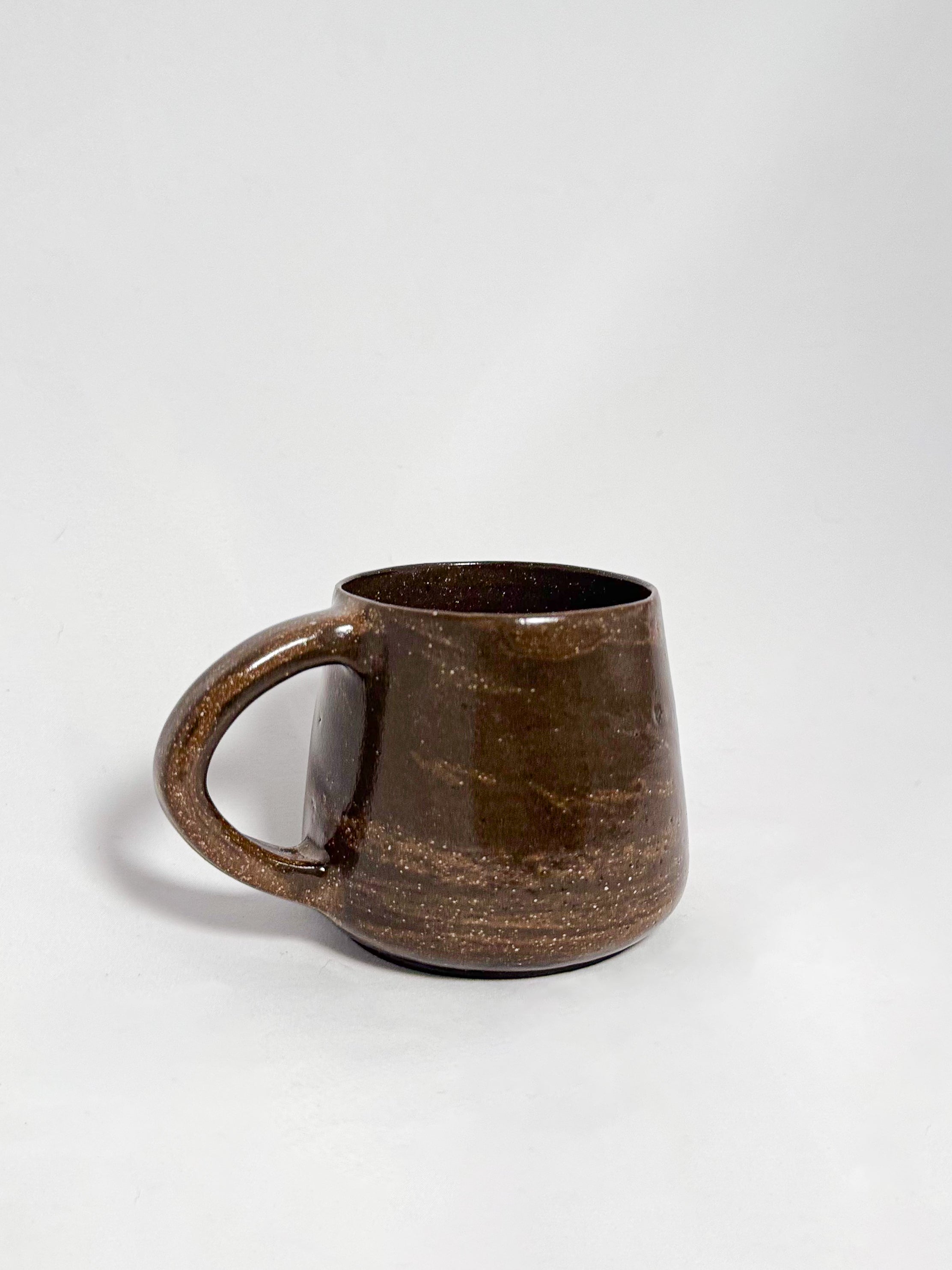 A brown marbled stoneware mug with swirls of light brown and dark brown clay