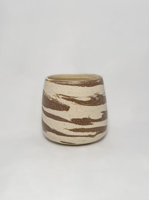 A marbled ceramic stoneware tumbler with brown and white clay
