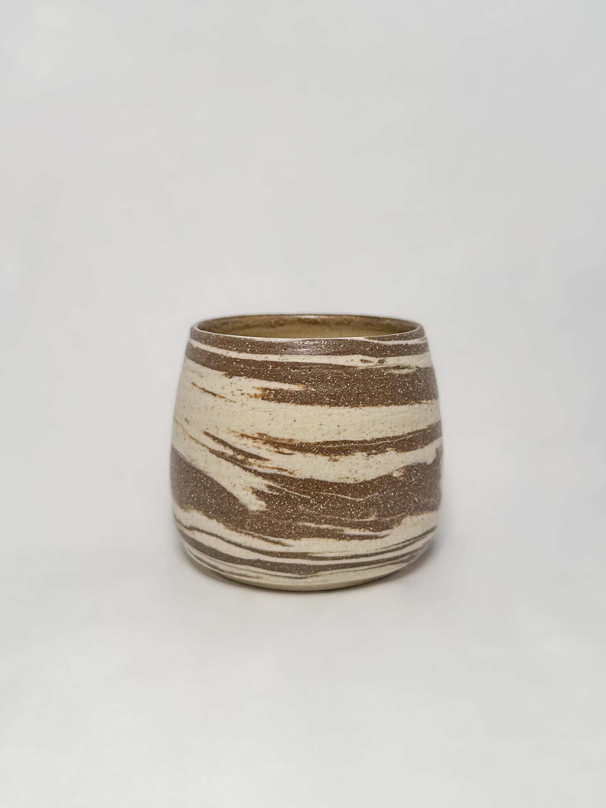A marbled ceramic stoneware tumbler with brown and white clay