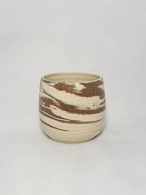 A marbled ceramic stoneware tumbler with brown and white clay